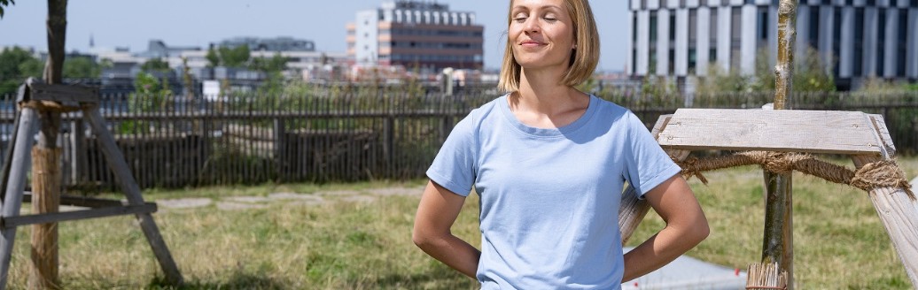 Magdalena Neuner steht auf einem Almdach in München und genießt mit geschlossenen Augen die Sonne.