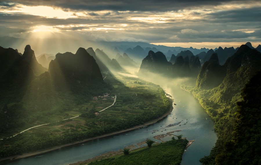 Fluss fließt durch ein nebliges Tal bei Sonnenaufgang